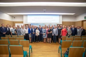 Zdjęcie samorządowców podczas podpisania wielostronnej deklaracji współpracy. Sala konferencyjna, ludzie stoją przed prezentacją, w tle na slajdzie wyświetla się tekst Metropolia 2.0